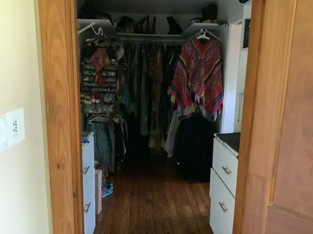 New walk-in closet with hanging rods and wood floors, part of a bathroom and closet addition